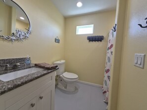 A bathroom with a sink, toilet, and shower curtain.