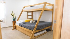 A bunk bed with a wooden frame, a potted plant, and a bedside table. - Beachfront Beach Break Villa @SurfCity (Conchalio)