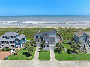 A coastal residential area with houses, a beach, and a boardwalk. - Sandcastle by Ryson Vacation Rentals (Galveston)