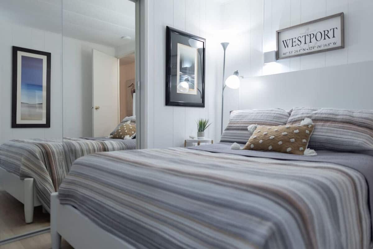 Ett hotellrum med två sängar, en inramad tavla, en lampa och en skylt som visar att platsen är Westport.