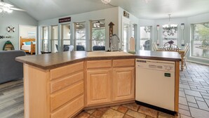 A modern kitchen with a wooden island, built-in dishwasher, and large windows offering views of the outdoors. - Bring Your Boat! Lakefront Home w/ Dock in Grove (Grove)