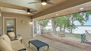 A covered deck with outdoor furniture, a ceiling fan, and a view of a lake. - Bring Your Boat! Lakefront Home w/ Dock in Grove (Grove)
