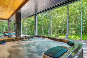 A hot tub with a view of a forest.