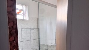 A bathroom with a glass shower enclosure, white tiled walls, and a visible window. - New Dawn. (Alto Paraíso de Goiás)