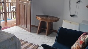 A room with a bed, a sofa, a TV, and a wooden stool. - New Dawn. (Alto Paraíso de Goiás)