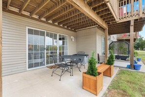 A covered patio with a table and chairs, wooden planters, and a wooden deck. - The Chic Retreat - Studio for 2 (Branson)