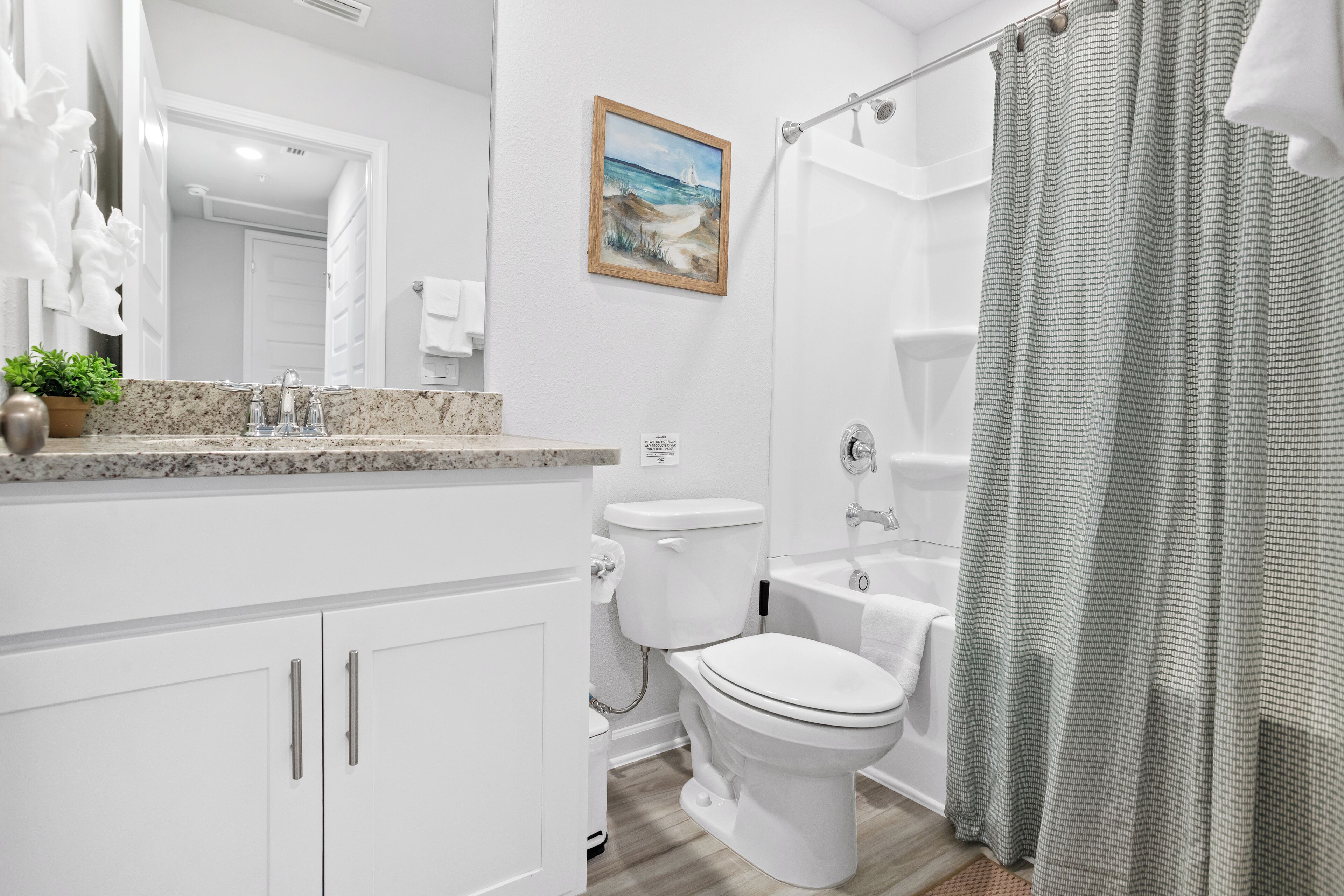 Un baño moderno con lavabo, inodoro y bañera blancos.