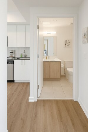A modern kitchen with white cabinets, a coffee maker, and a sink.