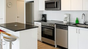 A modern kitchen with white cabinets, a microwave, a coffee maker, and a dishwasher. - Premium one bedroom apartment fully furnished /Northyork (Toronto)