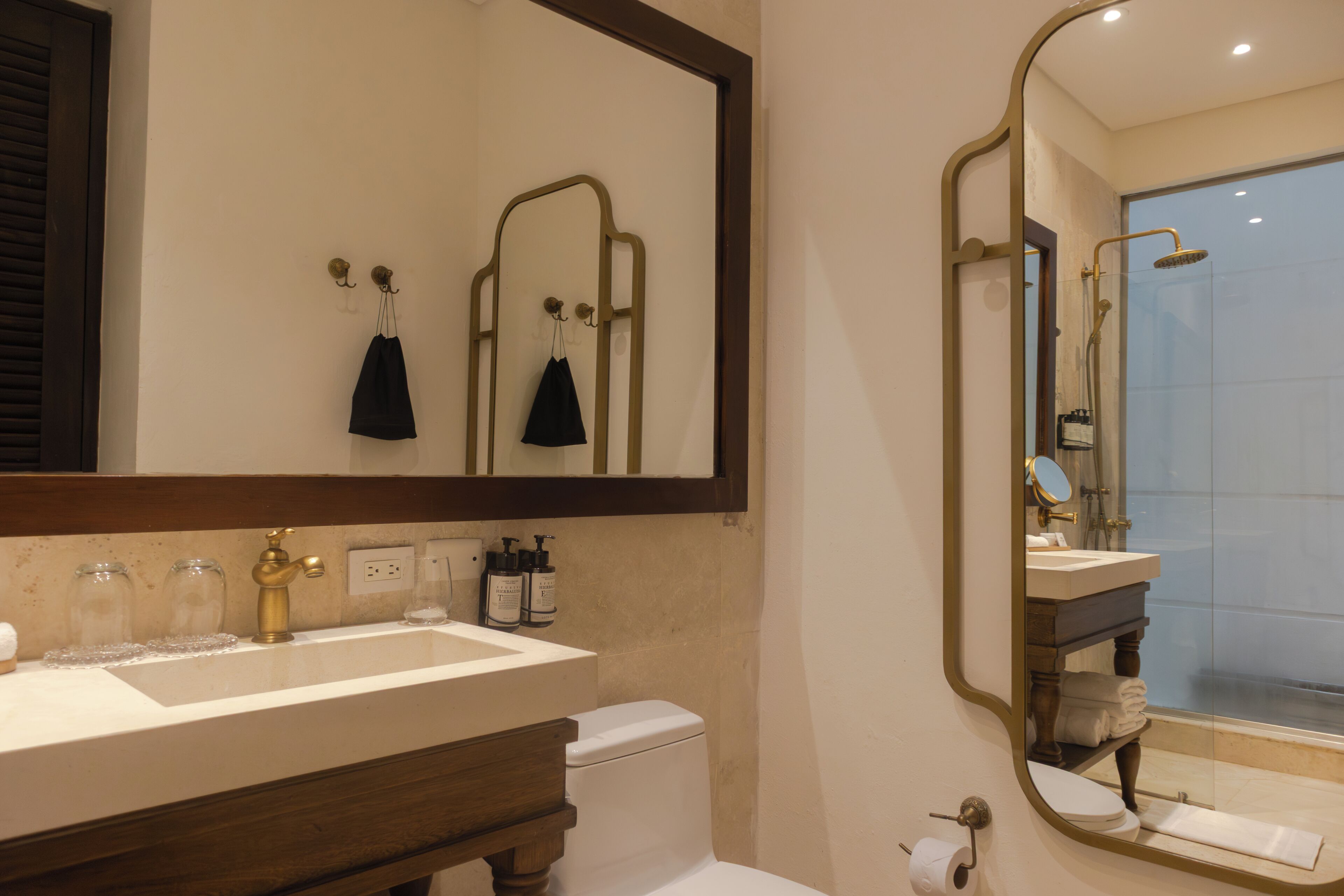 Een badkamer met een grote spiegel, een wastafel, toilet en douche.