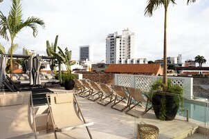 Una piscina al aire libre, sillones reclinables de piscina
