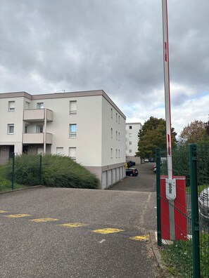 A multi-story residential building with a gated entrance and a parking area. - Charming apartment near Strasbourg - Your getaway with family or friends (Lingolsheim)