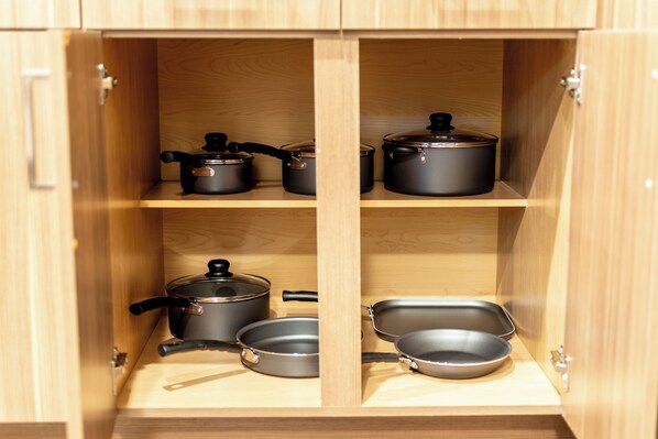 Un mueble de madera con varios estantes que contiene utensilios de cocina.