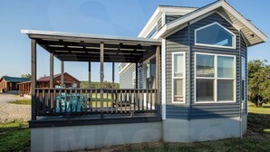 A house with a covered porch and a large window. - Tiny Home with AC in charming Hamilton cabin 15 (Hamilton)