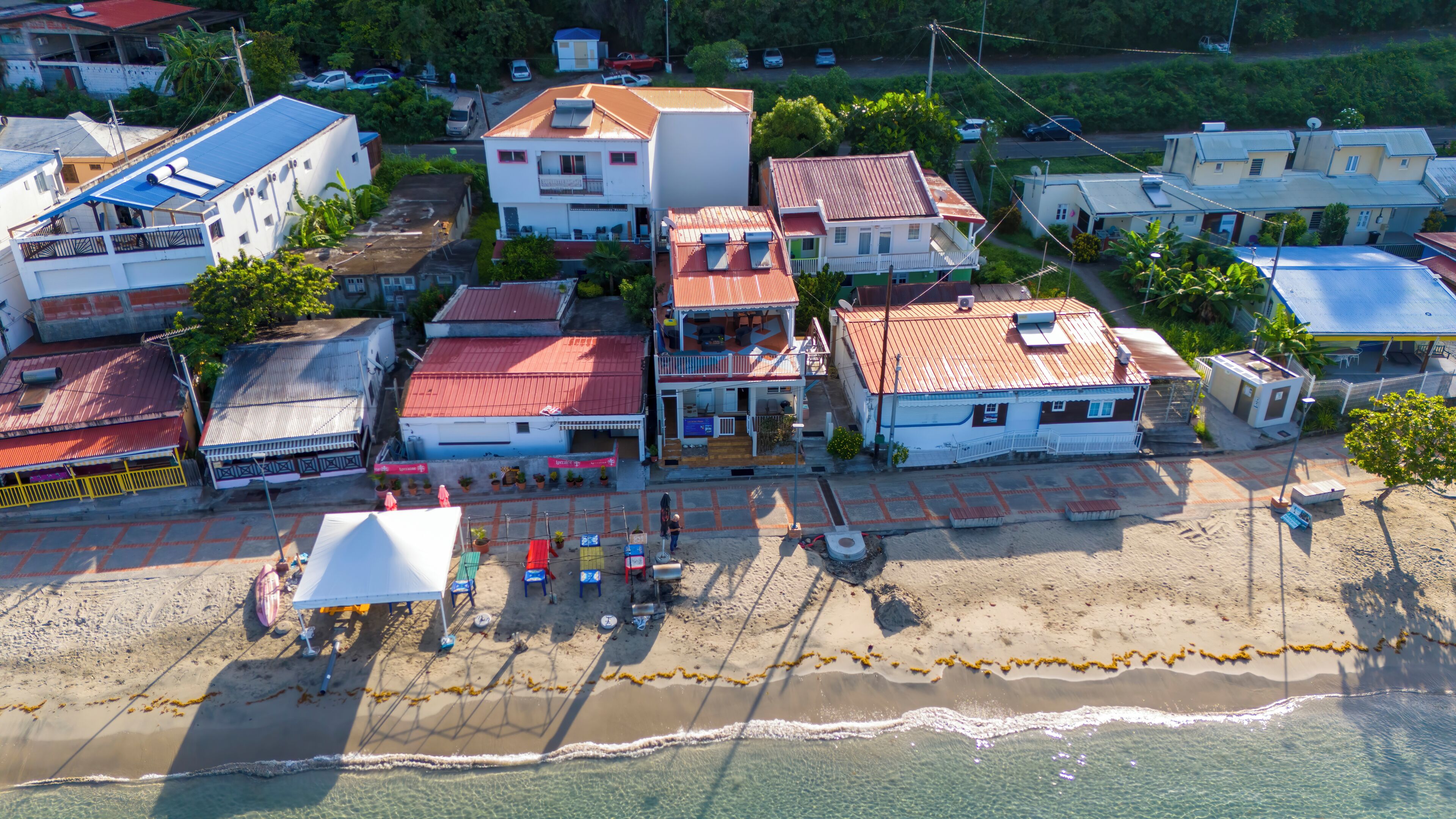 Vista aérea de un pueblo costero con edificios, una playa y una vista despejada del océano.
