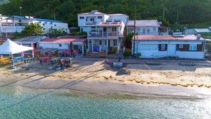 A coastal area with buildings, a sandy beach, and clear water. - LEZ'ARLET PLAGE  (Les Anses-d'Arlets)