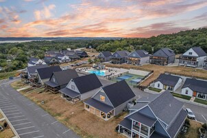 A residential area with multiple houses, a swimming pool, and a parking lot.