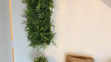 Une console noire avec un panier tressé et une petite plante en pot.