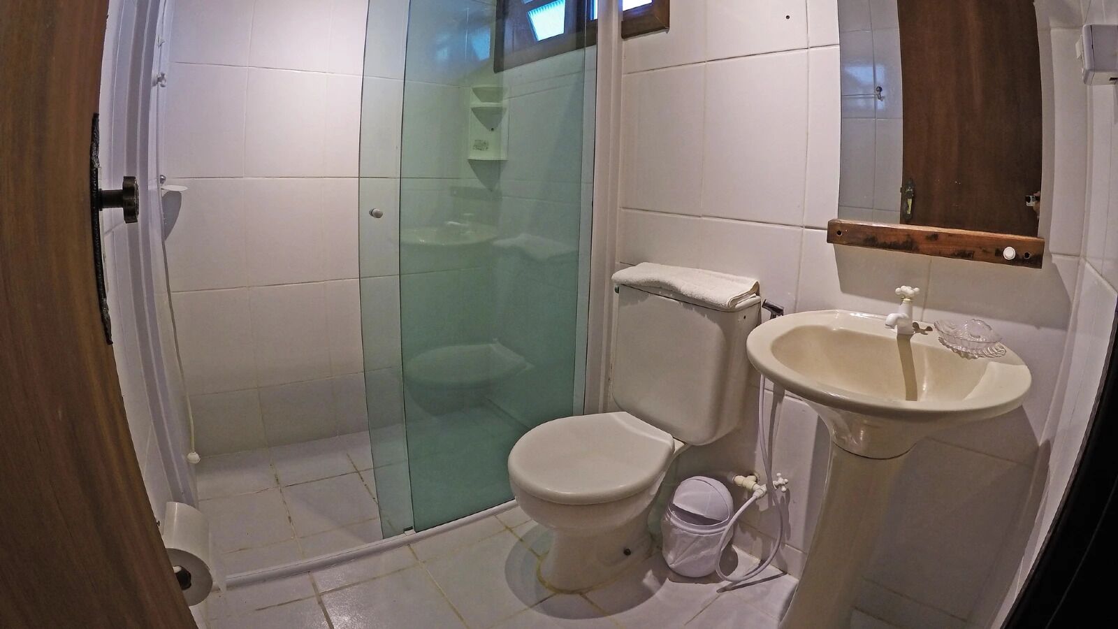 Un baño con ducha de vidrio, inodoro y lavamanos.