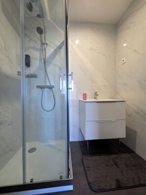 Een douche, handdoeken, zeep, shampoo