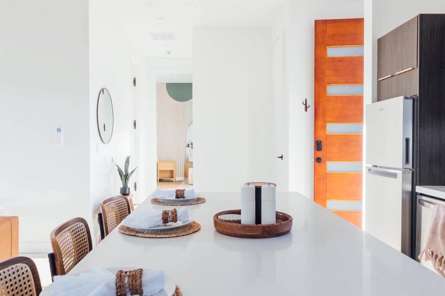 A modern kitchen with a large island, wooden cabinets, and a built-in oven.