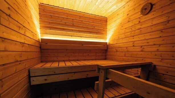 A sauna with wooden walls and benches. - Cozy Koivutie Apartment (Ranua)