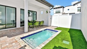 A modern house with a swimming pool, patio, and green lawn. - Comfortable Villa at Villa Domani Near 4bdrs (Davenport)