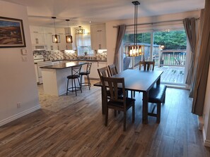 A modern kitchen with a central island, bar stools, and pendant lighting. - Country house with a forest trail and a mountain bike trail nearby. (Mandeville)