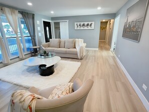 A modern living room with a sofa, a coffee table, and a view of the outdoors. - Schaumburg Modern 4BR Farmhouse w/ Private Master &  Sleeps 9. Families & groups (Schaumburg)