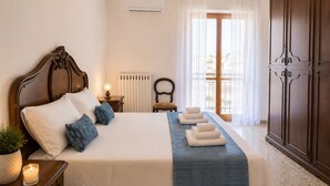 A neatly arranged bedroom with a bed, bedside table, lamp, radiator, chair, and wardrobe. - Dimora Peppino, a family friendly holiday home, just few step from the sea. (Polignano a Mare)