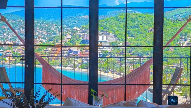 A room with a large window offering a view of a coastal town, a hammock, and a bed with pillows. - PISCIS CONDO
Dawn overlooking the most beautiful bay in Mexico. (Zihuatanejo)