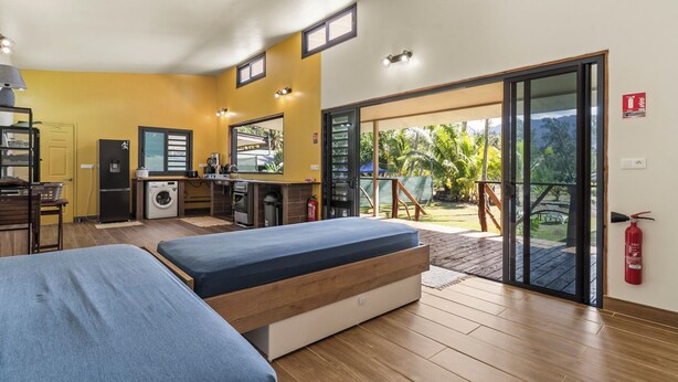 Una habitación de hotel compacta con kitchenette, una cama y un balcón con vistas al exterior.