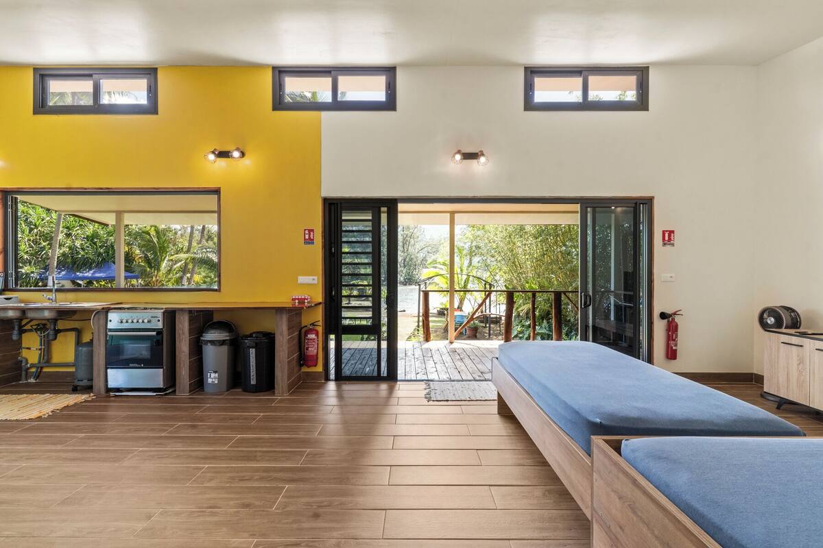 A room with a bed, a desk, and a view of the outdoors.