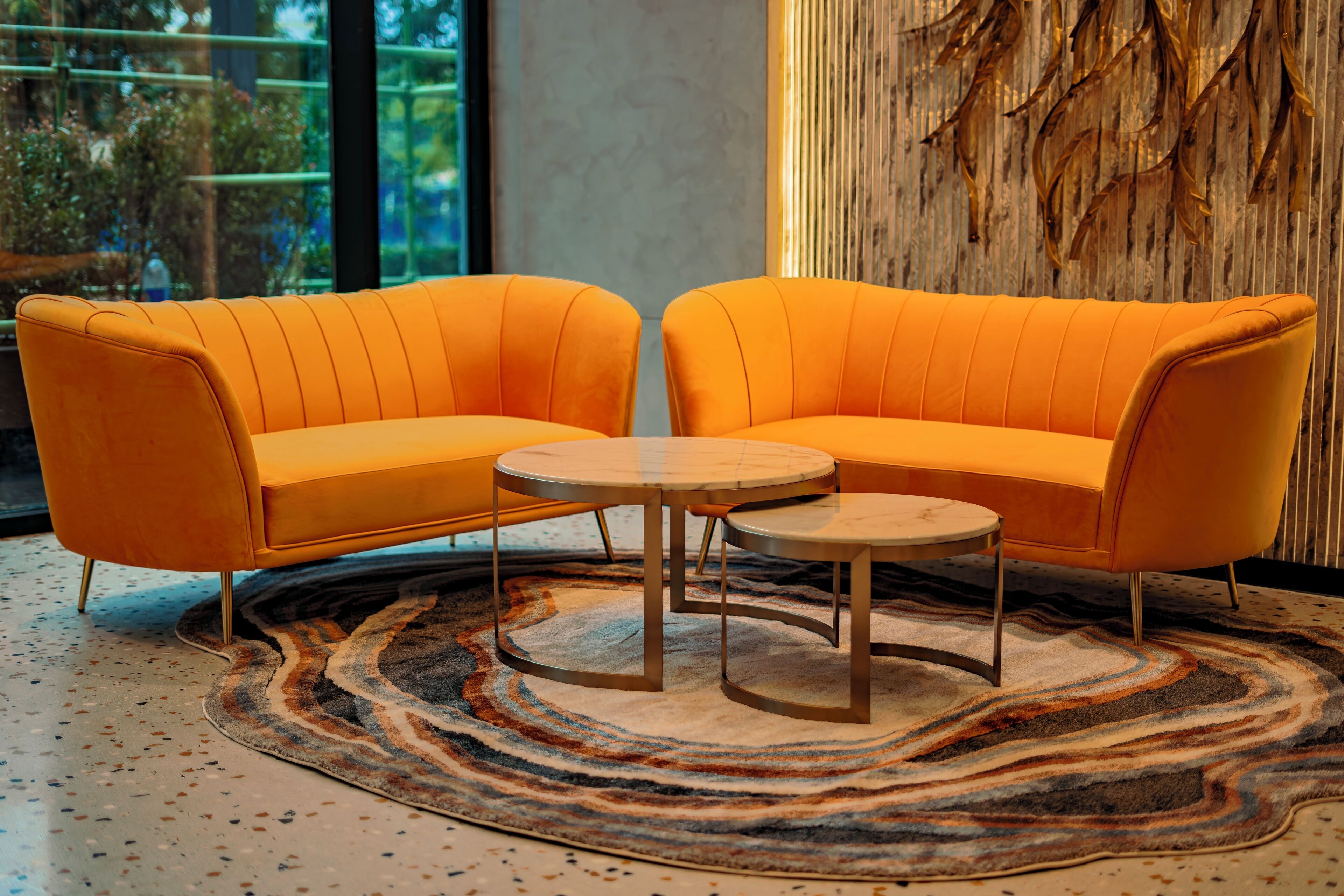 Une pièce moderne avec deux canapés orange et une petite table ronde.