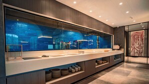 A modern bathroom with a large mirror, a sink, and a vanity with storage. - Welina Hotel  (Bhubaneshwar)
