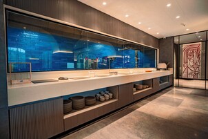 Un baño moderno con un espejo grande, un lavabo y un mueble de tocador con espacio de almacenamiento.