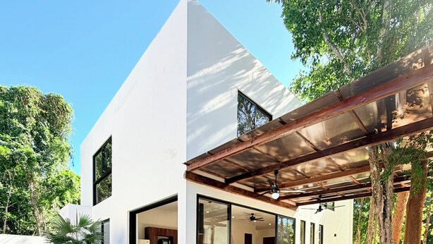 A modern house with a swimming pool, outdoor furniture, and a pergola.