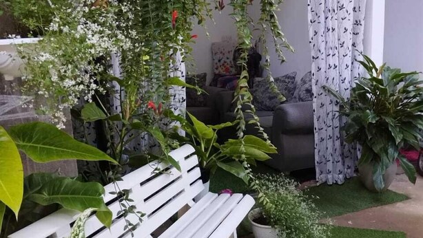 A cozy indoor garden with a white bench, various potted plants, and hanging greenery. - Ella Way Resort-Kandy (Hindagala)