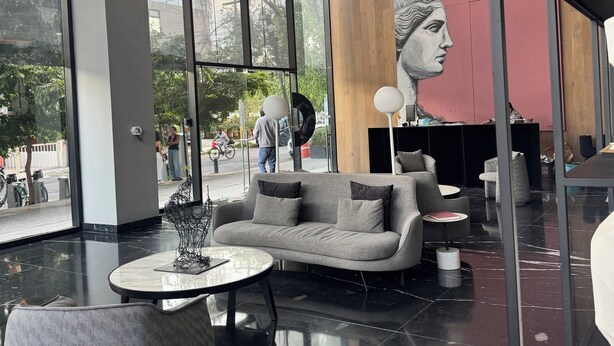 A modern interior with a sofa, round table, and hanging spherical light fixtures.