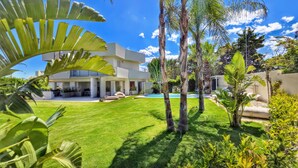 A modern house with a pool, surrounded by lush greenery and palm trees. - Shati Luxury- Private Heated Pool, sea view, two steps from beach (Fontane Bianche)