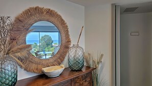 A room with a large round mirror, a wooden dresser, and decorative vases. - Shati Luxury- Private Heated Pool, sea view, two steps from beach (Fontane Bianche)