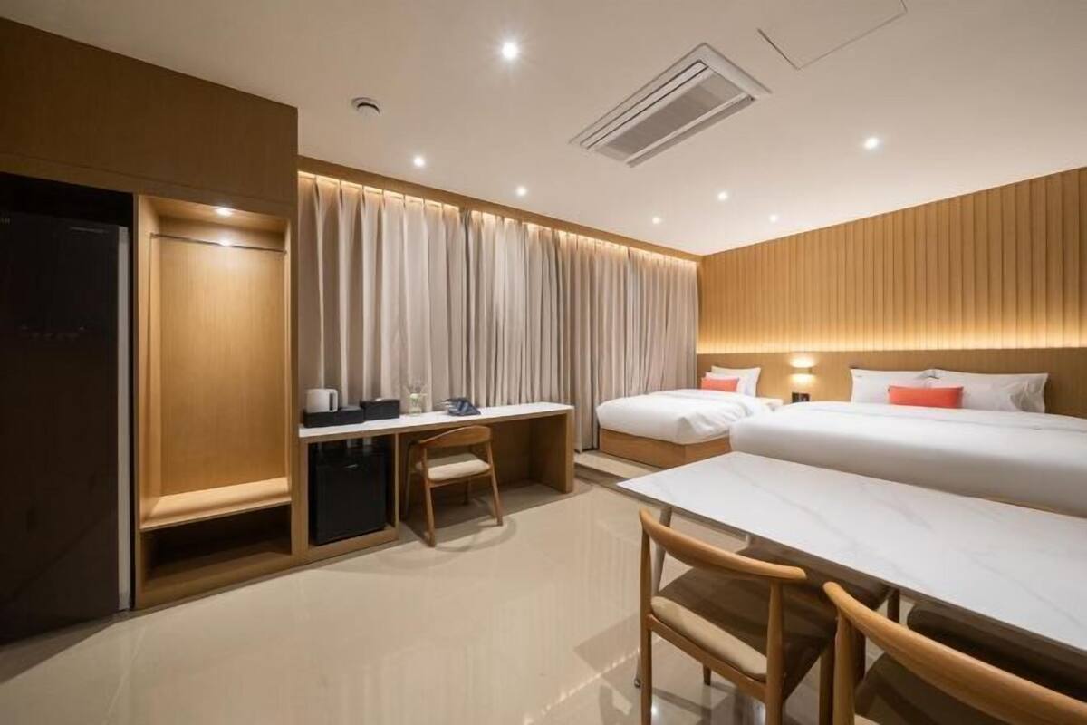 Habitación de hotel con cama, escritorio, silla y armario.