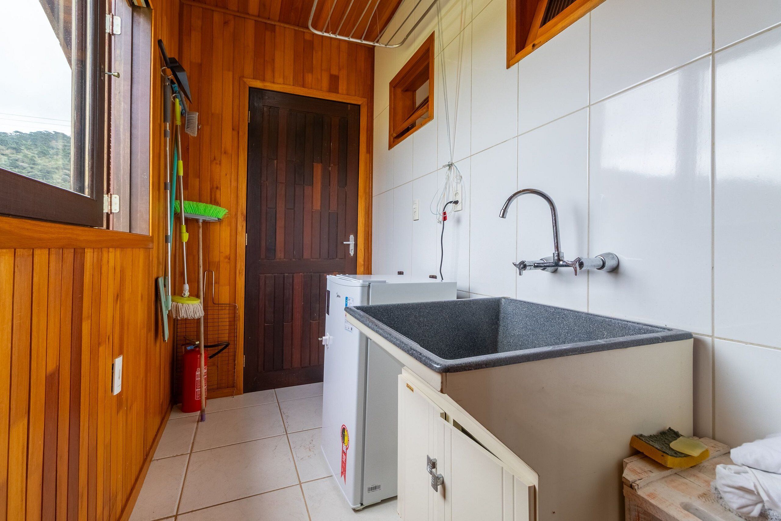 A compact kitchen with a sink, wooden cabinets, and a refrigerator.