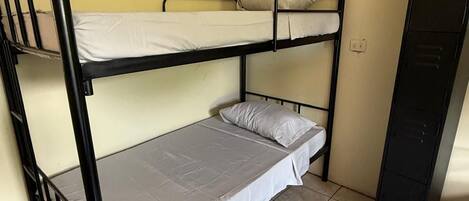 A bunk bed room with a tiled floor and a black wardrobe.