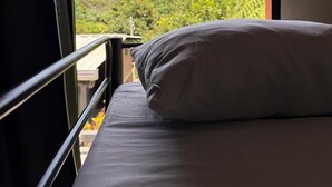 A bed with a view of mountains through an open window. - Villa San Carlos (Juayua)