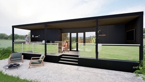 A modern outdoor deck with a glass balustrade, a wooden staircase, and seating areas. - Luxury lodges with views of Lancashire rolling hills & our beautiful golf course (Staining)
