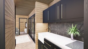 A modern kitchen with dark cabinets, a white countertop, and a potted plant. - Luxury lodges with views of Lancashire rolling hills & our beautiful golf course (Staining)