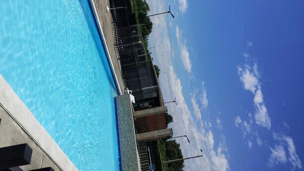 A swimming pool with clear blue water, surrounded by a fence and a few chairs. - Comfortable apartment south cali - valle de lilí with nature view (Cali)