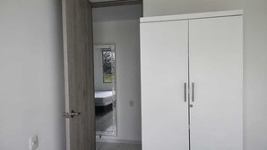 A room with a wardrobe, a door leading to another room, and a small window. - Comfortable apartment south cali - valle de lilí with nature view (Cali)