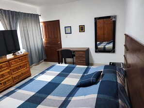 A bedroom with a bed, a desk, a dresser, a television, and a mirror. - Hospedaje Castillo (Santiago de Querétaro)